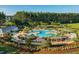 Aerial shot showing a large community pool with pergola-covered seating and playground surrounded by lush landscaping at 103 Radtko Rd, Summerville, SC 29486
