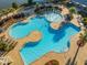 Aerial view of a community pool with ample seating, complemented by lush landscaping and a nearby lake at 103 Radtko Rd, Summerville, SC 29486