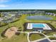 Aerial view of a pool, playground, and lake surrounded by homes in a well-maintained community at 103 Radtko Rd, Summerville, SC 29486