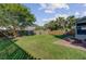 Large grassy backyard featuring mature trees, privacy fence, and a brick patio with fire pit at 1034 Sterling Ln, Summerville, SC 29483