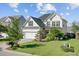 Two-story home with dark roof, light siding, attached garage, landscaping, and green grass at 104 Valentin Dr, Summerville, SC 29483
