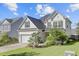 Two-story home with dark roof, light siding, landscaping, green lawn, and attached garage at 104 Valentin Dr, Summerville, SC 29483