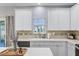 Bright kitchen with white cabinetry, modern fixtures, and decorative accents, showcasing a clean aesthetic at 104 Valentin Dr, Summerville, SC 29483