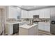 Well-lit kitchen with white cabinets, stainless steel appliances, tile backsplash, and a center island at 104 Valentin Dr, Summerville, SC 29483