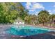 A community pool offers a relaxing outdoor experience with palm trees and a pool house in the background at 104 Valentin Dr, Summerville, SC 29483