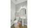 Well-lit powder room featuring a pedestal sink, mirror, and tile flooring at 104 Valentin Dr, Summerville, SC 29483