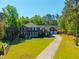 Aerial view of a two-story brick home with a well-maintained lawn, lush landscaping, and a three-car garage at 105 Birkbeck Ct, Goose Creek, SC 29445