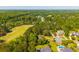 Aerial view of a residential area featuring a golf course and homes with pools surrounded by trees at 105 Birkbeck Ct, Goose Creek, SC 29445