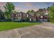 Lovely brick two-story home with a manicured lawn, long driveway, attached three-car garage, and blooming flowers at 105 Birkbeck Ct, Goose Creek, SC 29445