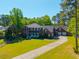 Beautiful brick two-story home with a well-manicured lawn, long driveway, and an attached three-car garage at 105 Birkbeck Ct, Goose Creek, SC 29445