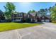 Traditional two-story brick home with manicured lawn, lush landscaping, and a spacious three-car garage at 105 Birkbeck Ct, Goose Creek, SC 29445
