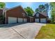 Brick home featuring a large driveway and multiple garage doors perfect for car enthusiasts at 105 Birkbeck Ct, Goose Creek, SC 29445