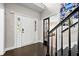 Bright foyer featuring a white front door, dark wood flooring, and an open staircase with a black railing at 105 Birkbeck Ct, Goose Creek, SC 29445