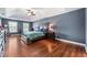 Main bedroom with a tray ceiling, hardwood floors, two windows, and stylish dark wood furniture at 105 Birkbeck Ct, Goose Creek, SC 29445