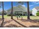 Inviting backyard with a covered patio, lush lawn, and charming bench seating amidst mature trees at 108 Bluff Isle Ct, Summerville, SC 29486
