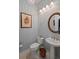 Bathroom with soft gray walls, pedestal sink, and round mirror at 108 Bluff Isle Ct, Summerville, SC 29486