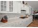 Bright kitchen features white cabinets, stone countertops, gas range, and glass front upper cabinets at 108 Bluff Isle Ct, Summerville, SC 29486