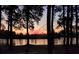 Tranquil lake view at sunset, framed by silhouette of trees, creating a serene and peaceful ambiance at 108 Bluff Isle Ct, Summerville, SC 29486