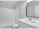 Well-lit bathroom featuring a shower-tub combo with white tile surround and modern vanity with a black framed mirror at 108 Wadmalaw Cir, Summerville, SC 29483