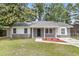 Charming single-story home featuring a gray brick facade, well-manicured lawn, and mature trees, creating an inviting curb appeal at 108 Wadmalaw Cir, Summerville, SC 29483