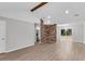 Bright and spacious living area with wood-look floors, a brick accent wall, and seamless flow into the kitchen and dining spaces at 108 Wadmalaw Cir, Summerville, SC 29483