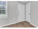 Practical mud room featuring wood-look flooring, white walls, and a window for natural light, perfect for organization at 108 Wadmalaw Cir, Summerville, SC 29483