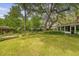 Expansive backyard featuring lush lawn, mature trees, and a brick-bordered patio at 110 Jackson Rd, Ladson, SC 29456