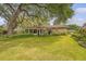 Backyard showing the house, manicured lawn, patio, and lovely oak trees and landscaping at 110 Jackson Rd, Ladson, SC 29456