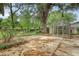 Large backyard with a greenhouse, patio, and mature trees, perfect for gardening at 110 Jackson Rd, Ladson, SC 29456