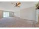 Open living area with neutral carpet and light walls, featuring a ceiling fan and backyard access at 110 Jackson Rd, Ladson, SC 29456