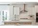 An airy kitchen features white cabinets, a stone countertop island, and stainless steel appliances at 1124 Darling St, Summerville, SC 29485