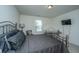 Bedroom with metal bed and desk, TV, two windows and gray color palette at 1146 Moss Grove Dr, Moncks Corner, SC 29461