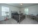 Neutral bedroom with modern metal bed frame, desk, two windows, and carpeted floor at 1146 Moss Grove Dr, Moncks Corner, SC 29461