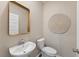 Modern powder room with pedestal sink, decorative mirror, and earth-toned decor offers a stylish and functional space at 1149 Darling St, Summerville, SC 29485