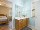 Bathroom with wood-look vanity, framed mirror, and view into Primary bedroom at 117 Blue Bonnet St, Summerville, SC 29483