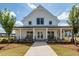 Exterior of stunning clubhouse featuring a covered porch with rocking chairs at 119 Summer Tanager Dr, Ravenel, SC 29470