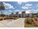 Exterior view of modern clubhouse, with landscaped grounds, walking path and bike rack at 119 Summer Tanager Dr, Ravenel, SC 29470