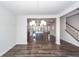 Dining area opening to kitchen features wood flooring and a modern chandelier at 119 Summer Tanager Dr, Ravenel, SC 29470