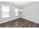 Bright dining room featuring wood floors, large windows, and a modern chandelier at 119 Summer Tanager Dr, Ravenel, SC 29470