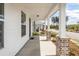 Long front porch view, showcasing white siding and brick column bases overlooking the community at 119 Summer Tanager Dr, Ravenel, SC 29470