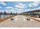 Outdoor horseshoe pits with lounge seating, a community pool and neighborhood homes in the background at 119 Summer Tanager Dr, Ravenel, SC 29470
