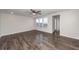 Open-concept living room showcasing hardwood floors, a ceiling fan, and natural light from the windows at 119 Summer Tanager Dr, Ravenel, SC 29470