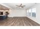 Bright living room with hardwood floors, ceiling fan, and adjacent modern kitchen featuring a blue island at 119 Summer Tanager Dr, Ravenel, SC 29470