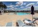 Community swimming pool featuring lounge chairs, sun umbrellas and community homes in the background at 119 Summer Tanager Dr, Ravenel, SC 29470