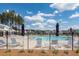 Community swimming pool and lounge chairs with community homes in the background behind a black fence at 119 Summer Tanager Dr, Ravenel, SC 29470