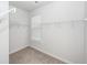 Bright walk-in closet featuring white shelving and neutral carpet at 119 Summer Tanager Dr, Ravenel, SC 29470