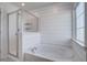 Bright bathroom with tub, glass-enclosed shower, and horizontal plank accent wall at 124 Sumac Dr, Goose Creek, SC 29445