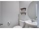 Half bathroom featuring a pedestal sink, round mirror, open shelves, and toilet at 124 Sumac Dr, Goose Creek, SC 29445