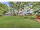 Spacious backyard with mature landscaping, featuring a pool and a modern white farmhouse at 126 Sparrow Dr, Isle of Palms, SC 29451