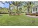 Expansive backyard featuring a lush lawn, mature trees, and a charming patio area at 126 Sparrow Dr, Isle of Palms, SC 29451